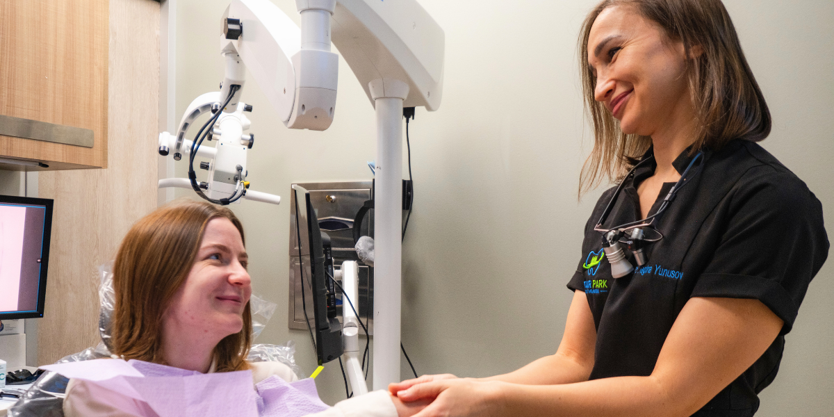 Dr. Regina Yunusov providing gentle, compassionate care to a happy patient during dental consultation